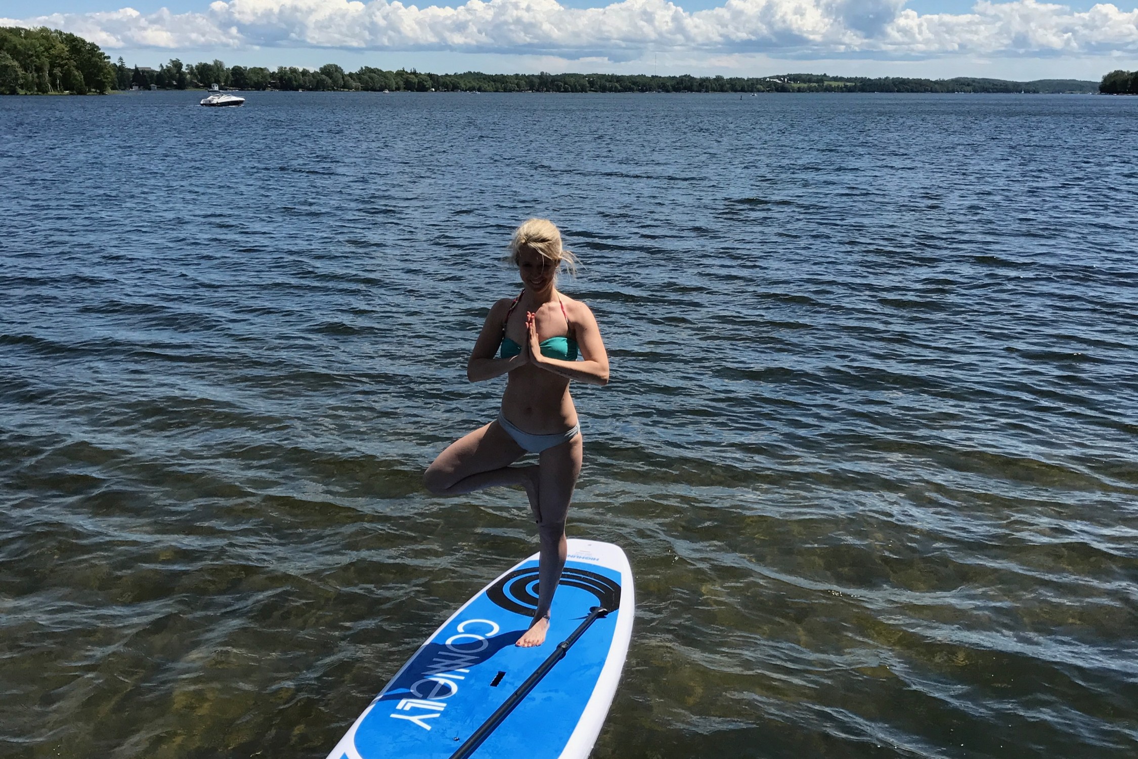 Woman standing on one leg on a standup paddleboard